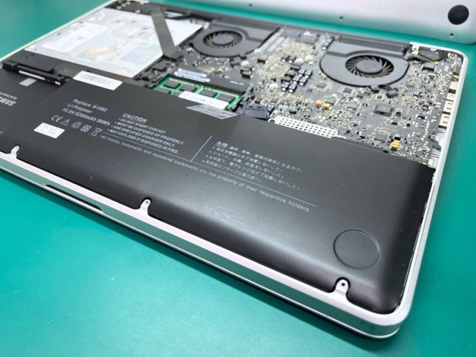 裏蓋を開けたMacBook Proの、膨張したバッテリー